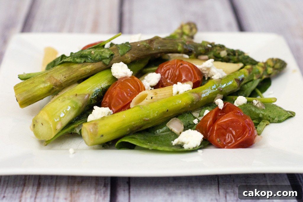 This versatile pasta salad combines roasted asparagus and tomatoes with penne and spinach, dressed in a low-calorie lemon vinaigrette. #CLBlogger TheRedheadBaker.com