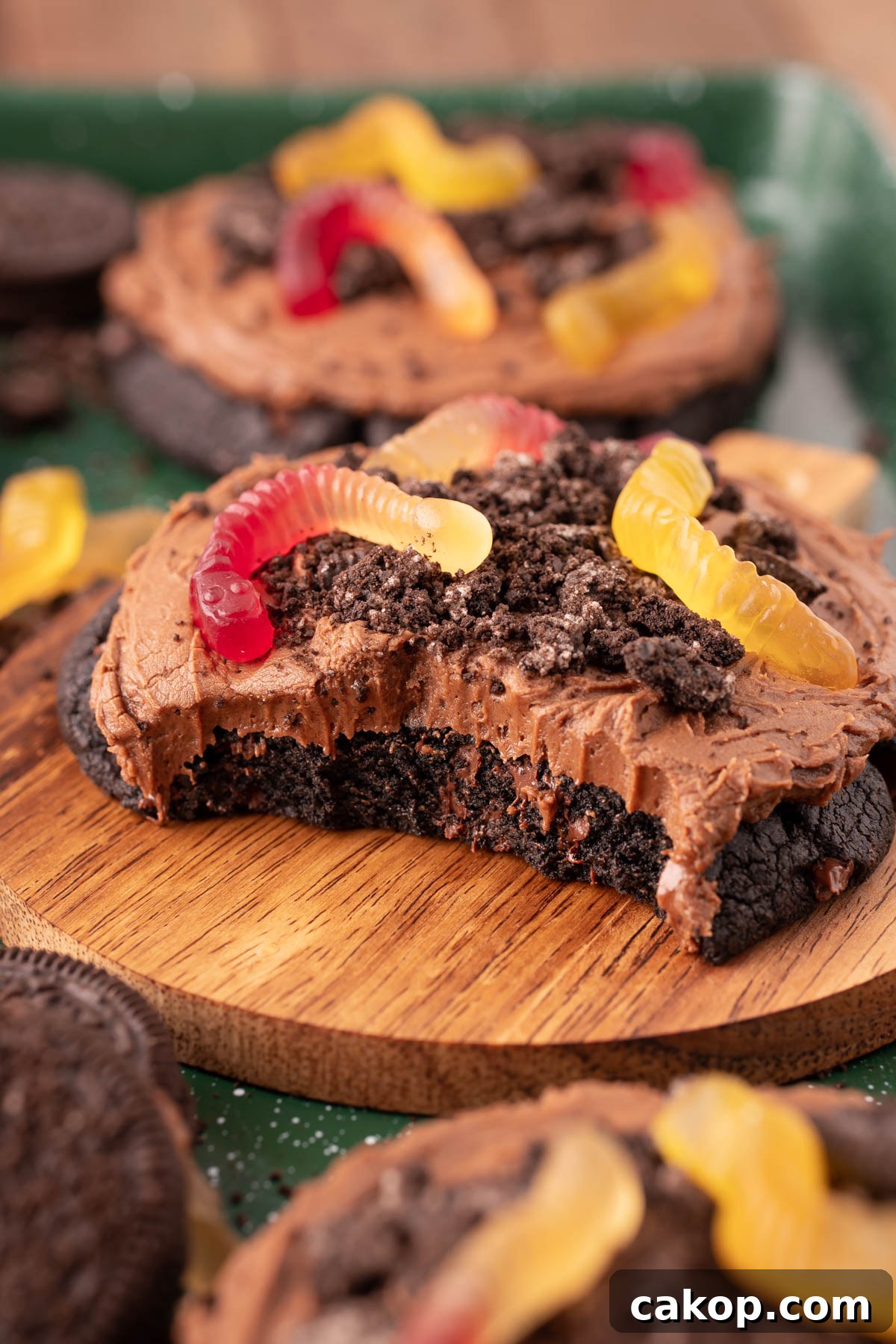 Dirt Cake Cookie on a wooden plate with bites taken out of it to show the texture inside.
