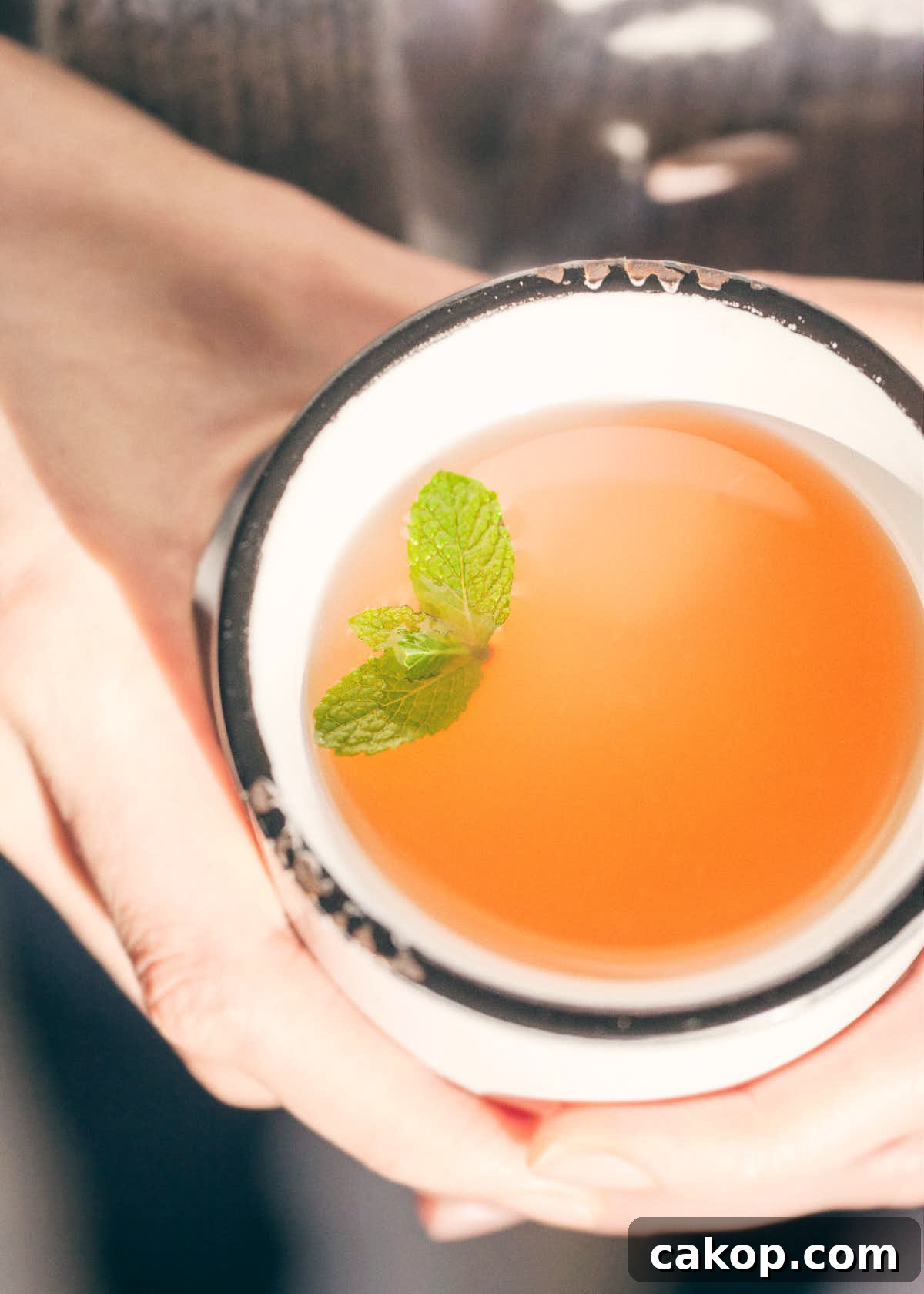 Holding grapefruit honey mint tea on a cold winter day