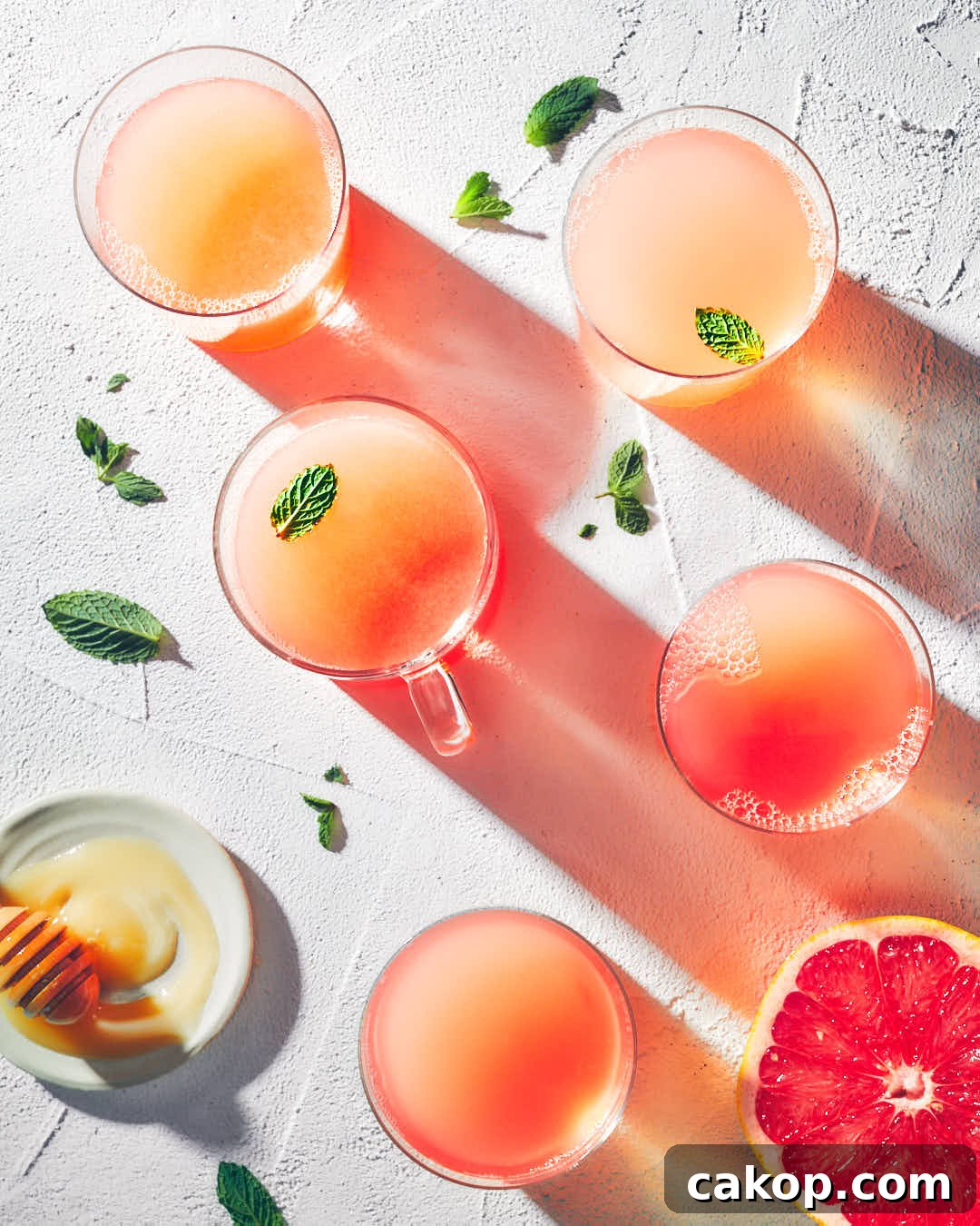 Five cups of grapefruit honey mint tea on a stone table