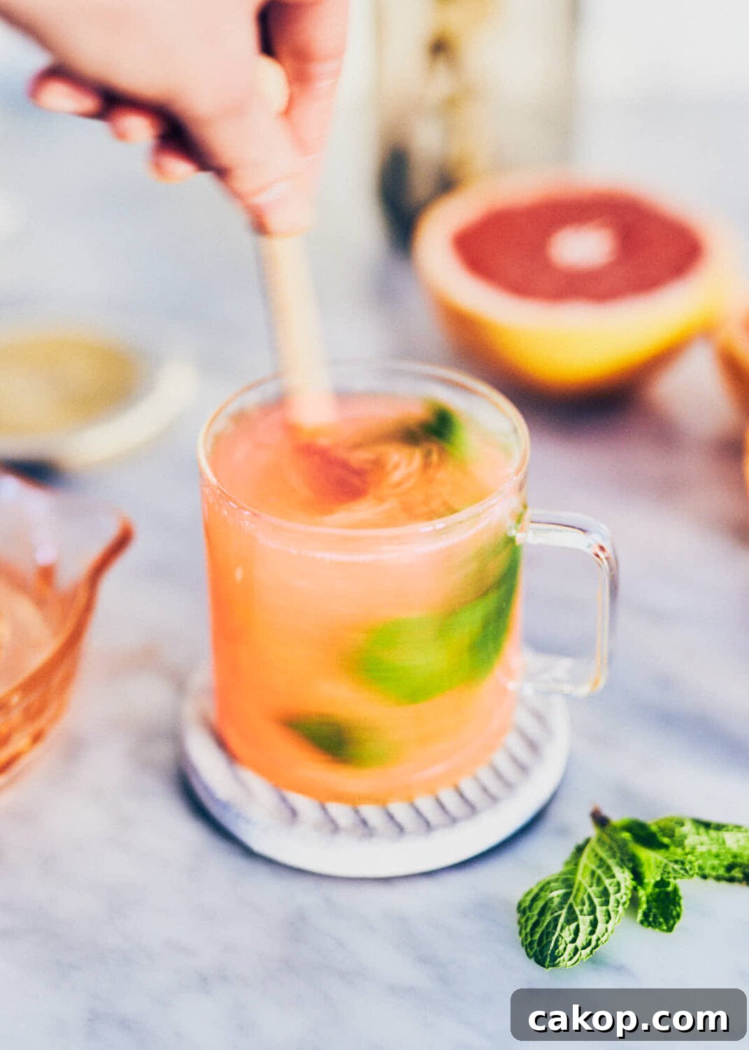 Stirring grapefruit honey mint tea