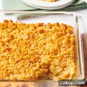 A baking dish of pineapple casserole with a serving missing.