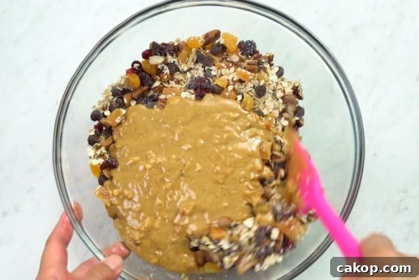 Peanut butter mix being poured over dry ingredient mix