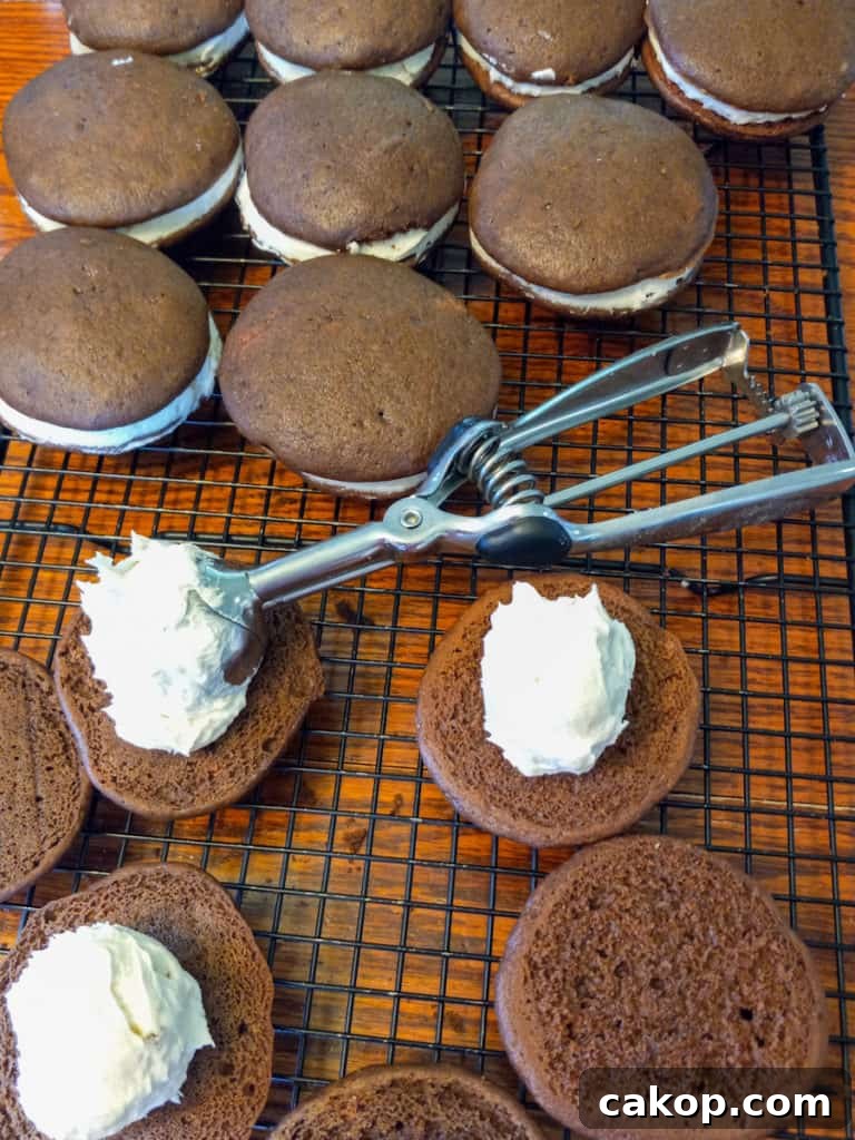 Amish Chocolate Whoopie Pies Recipe — Classic Soft Sandwich Cakes 7 scooping frosting onto the cookies.