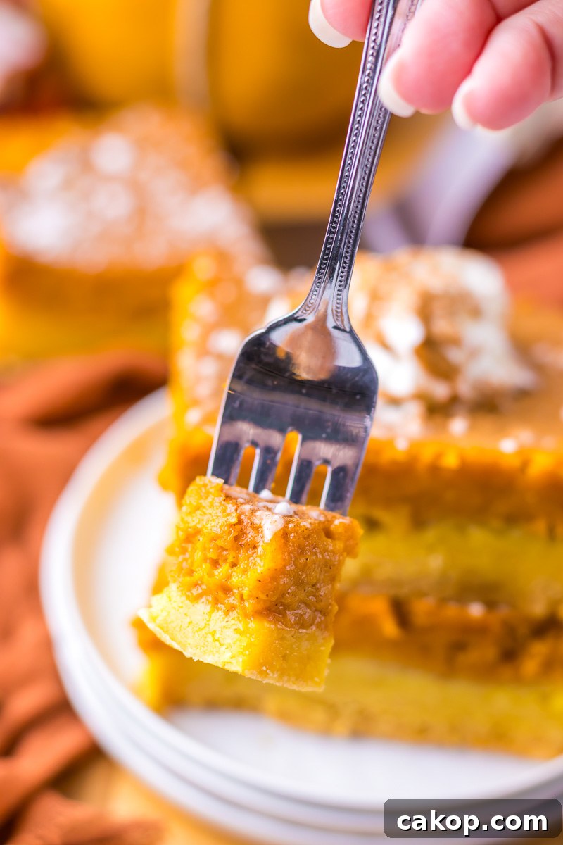 Pumpkin Gooey Butter Cake Recipe — Decadent Autumn Dessert 3 Bite of pumpkin gooey butter cake on a fork.