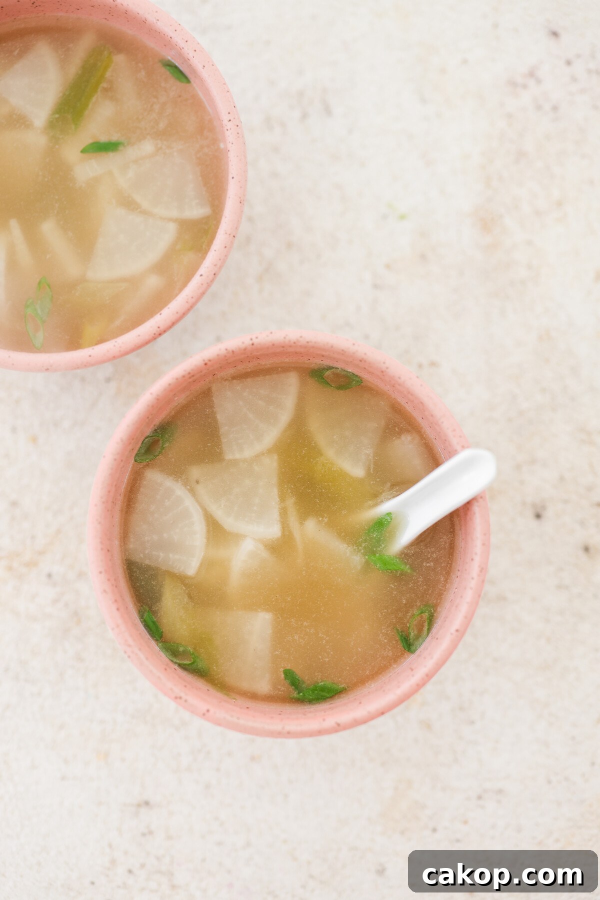 two pink bowls filled with Korean radish soup