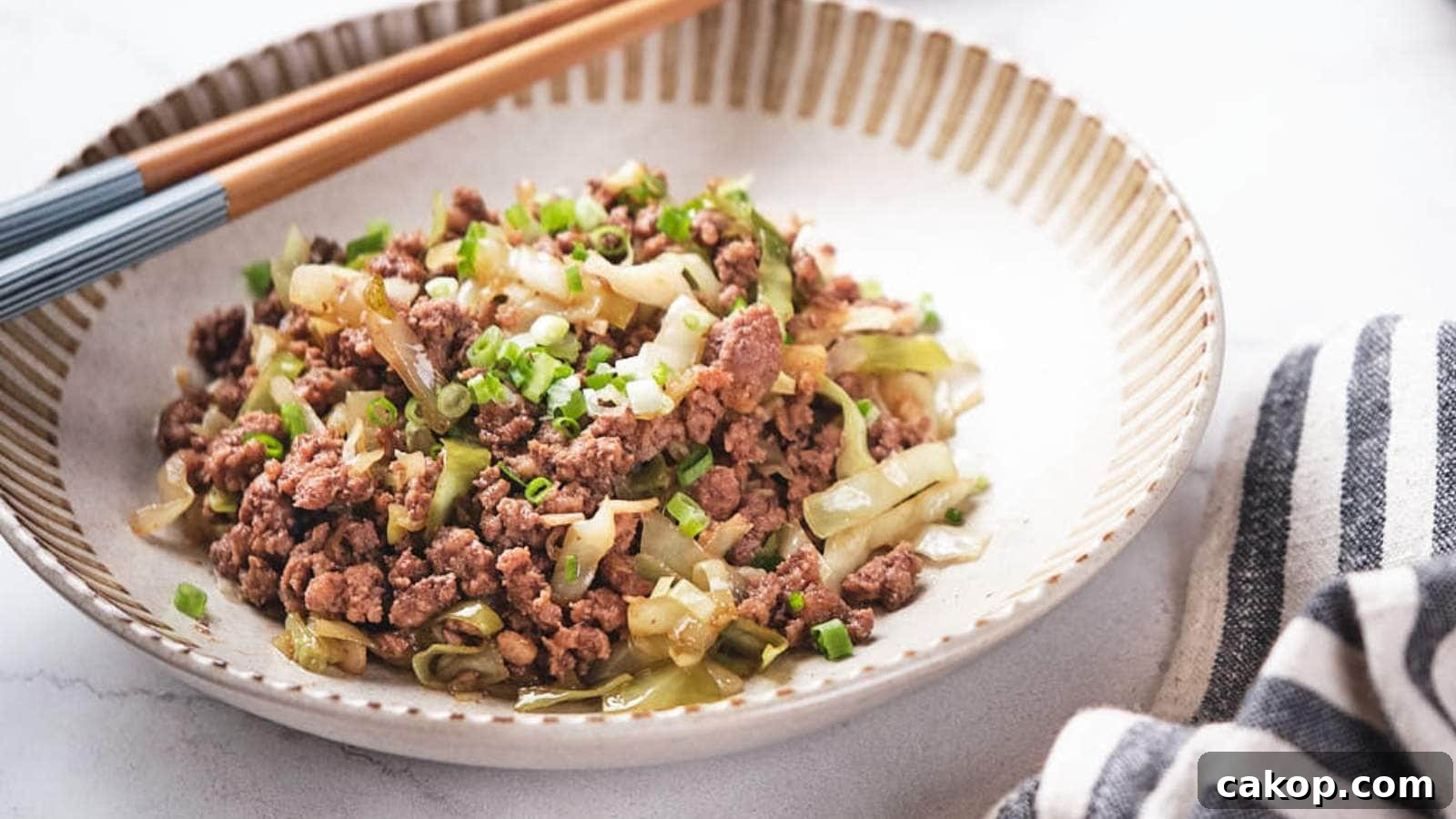 Ground beef and cabbage stir fry being scooped out from a skillet.