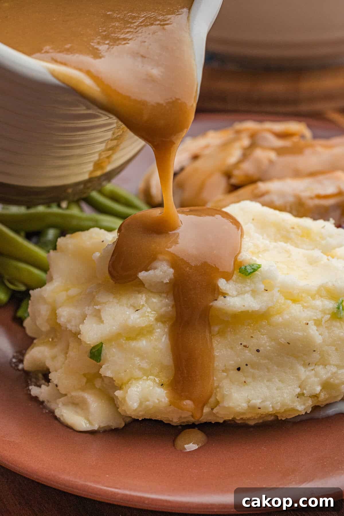 Classic Old-Fashioned Mashed Potatoes Recipe for Creamy Comfort 3 Gravy being poured over classic mashed potatoes.
