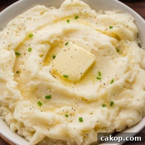 Classic Old-Fashioned Mashed Potatoes Recipe for Creamy Comfort 10 Creamy old-fashioned mashed potatoes in a bowl, topped with a square of butter, melted butter, black pepper, and chopped chives.