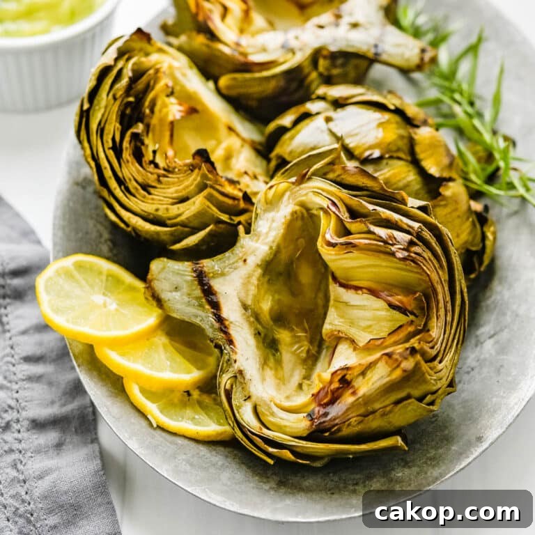 Grilled artichokes with slices of lemon on the side.