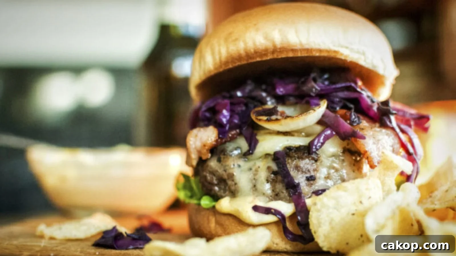 Brat burger topped with sauerkraut and mustard stacked tall on a toasted bun.