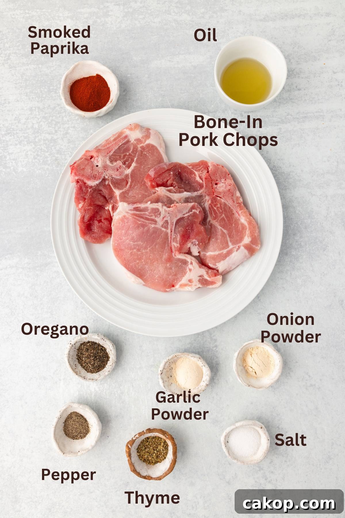 Juicy Bone-In Pork Chops: Simple Step-by-Step Cooking Guide 3 Smoked paprika, oil, and pork chops with seasonings on a white plate.