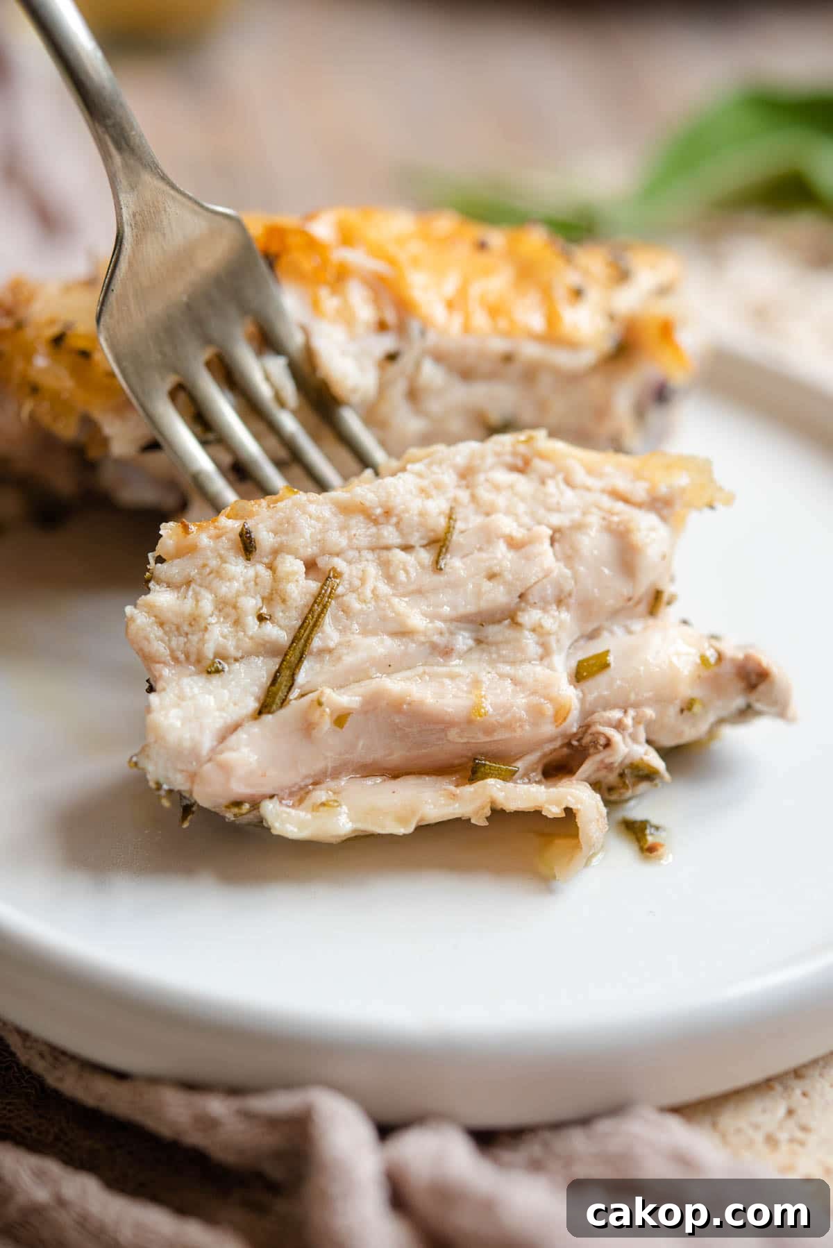 Crispy Italian-Style Baked Chicken Thighs 5 A close up of a juicy piece of chicken on a fork