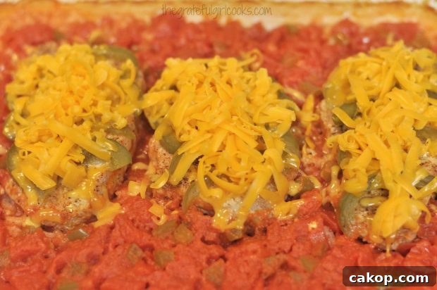 Baked pork chops olé are covered with cheese, placed back in oven to melt cheese.