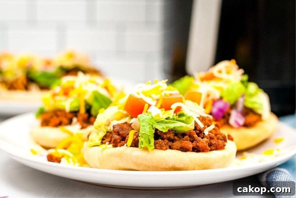 Crispy Air Fryer Navajo Tacos Recipe for Quick Weeknight Meals 5 close up of air fryer navajo tacos after cooking with lettuce, cheese, tomatoes, and onions