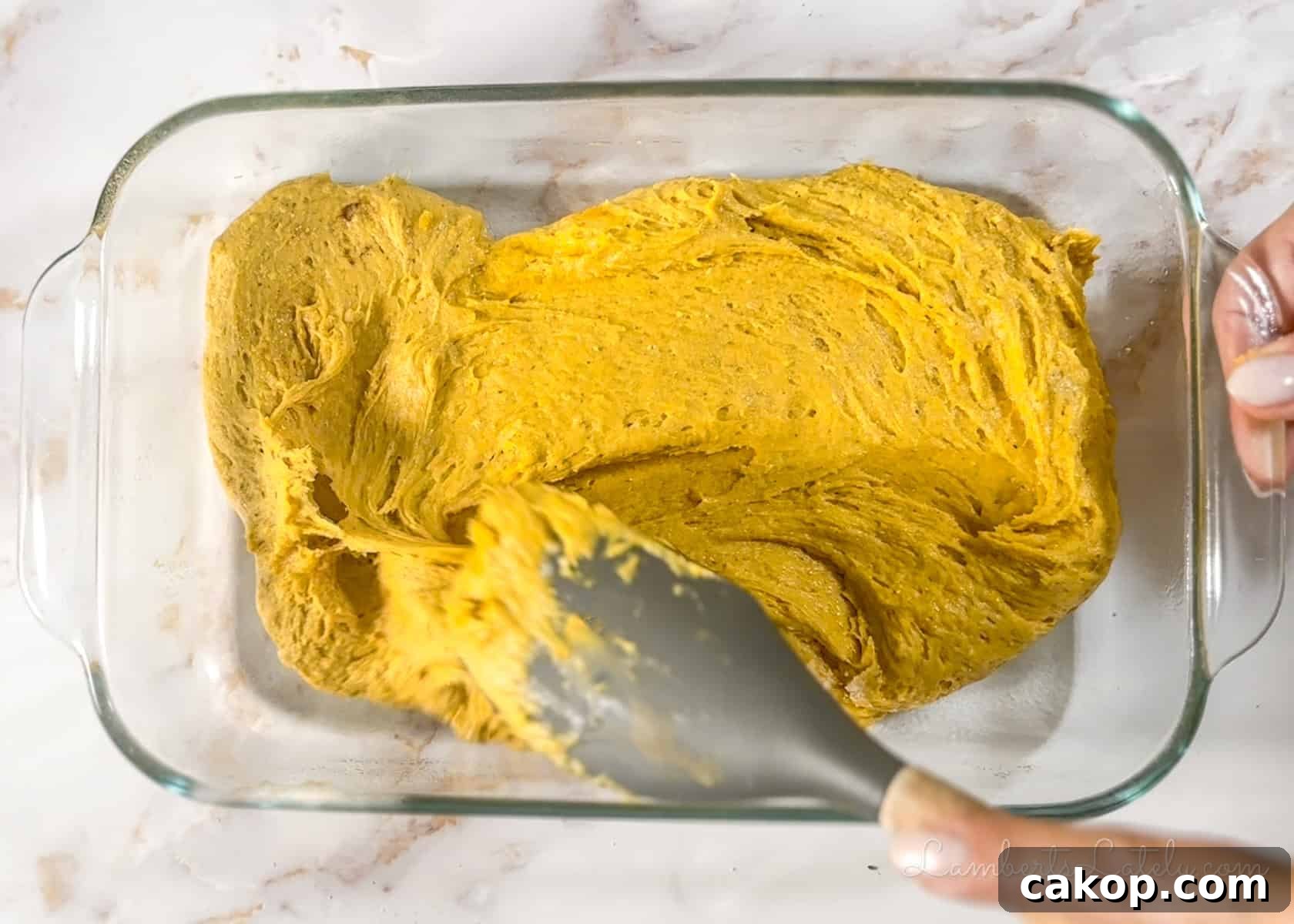 spreading pumpkin bar batter in a glass dish.