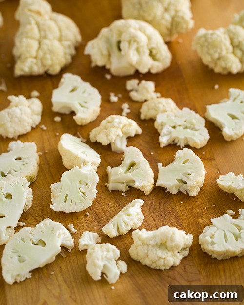 Crispy Roasted Cauliflower with Parmesan and Garlic 3 Scattered cauliflower florets on a cutting board.