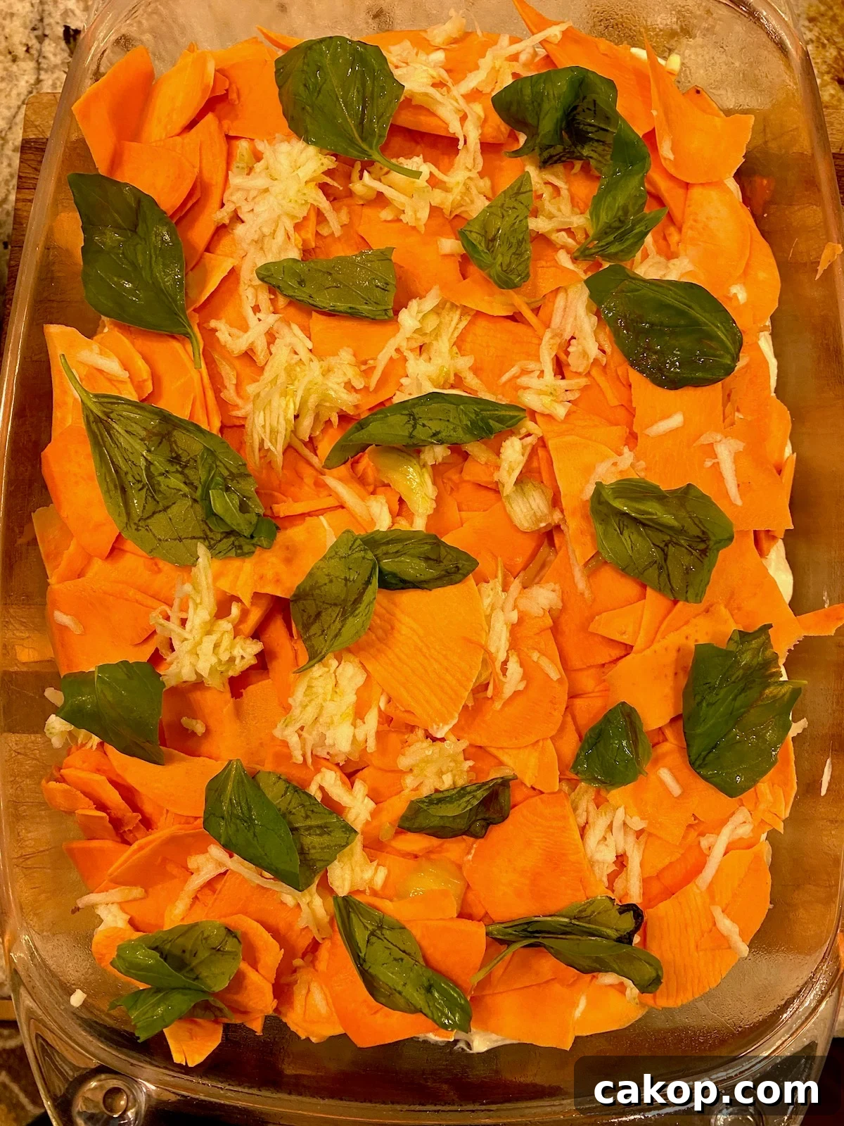 Sweet Potato Lasagna Recipe with Creamy Ricotta and Spinach 10 Fresh basil on top of sliced sweet potatoes in a baking dish