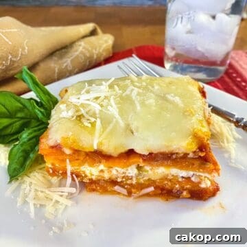 Sweet Potato Lasagna Recipe with Creamy Ricotta and Spinach 20 A serving of sweet potato lasagna on a plate with a glass of water off to the side.