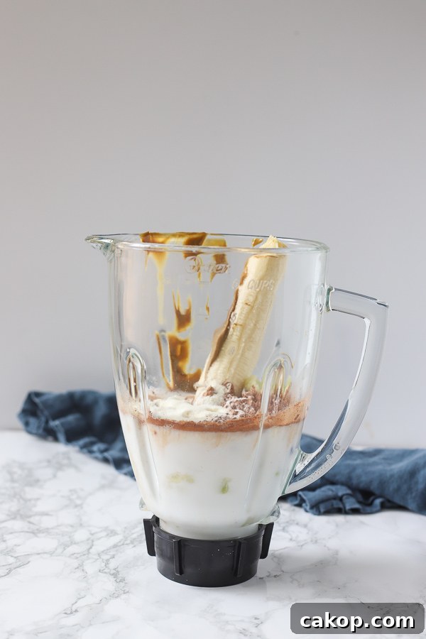 milk, cocoa powder, banana, nut butter, and cauliflower in a blender.