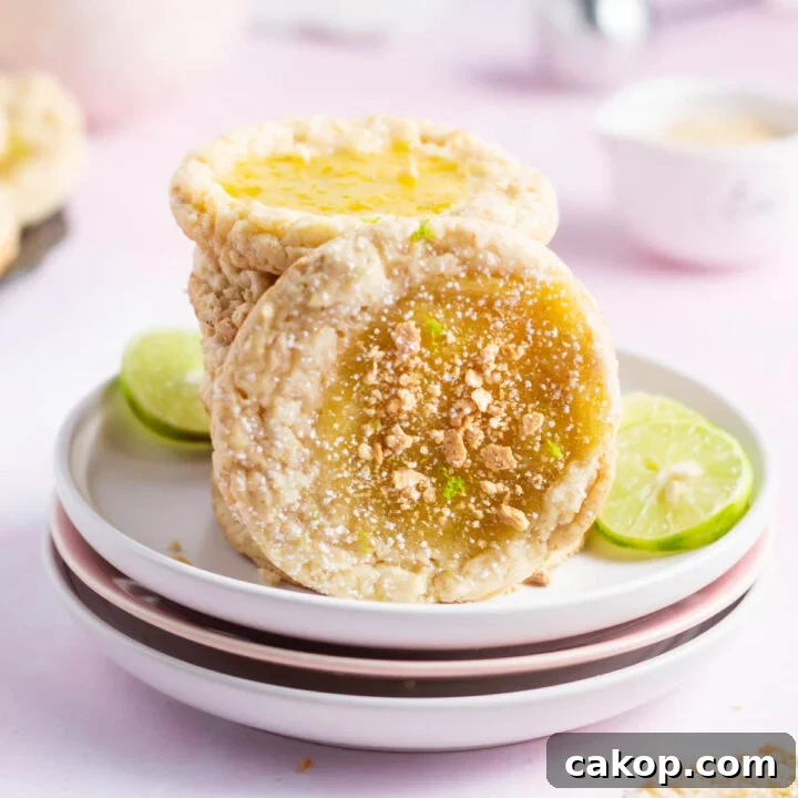 key lime cookie leaning against a stack of cookies on a plate