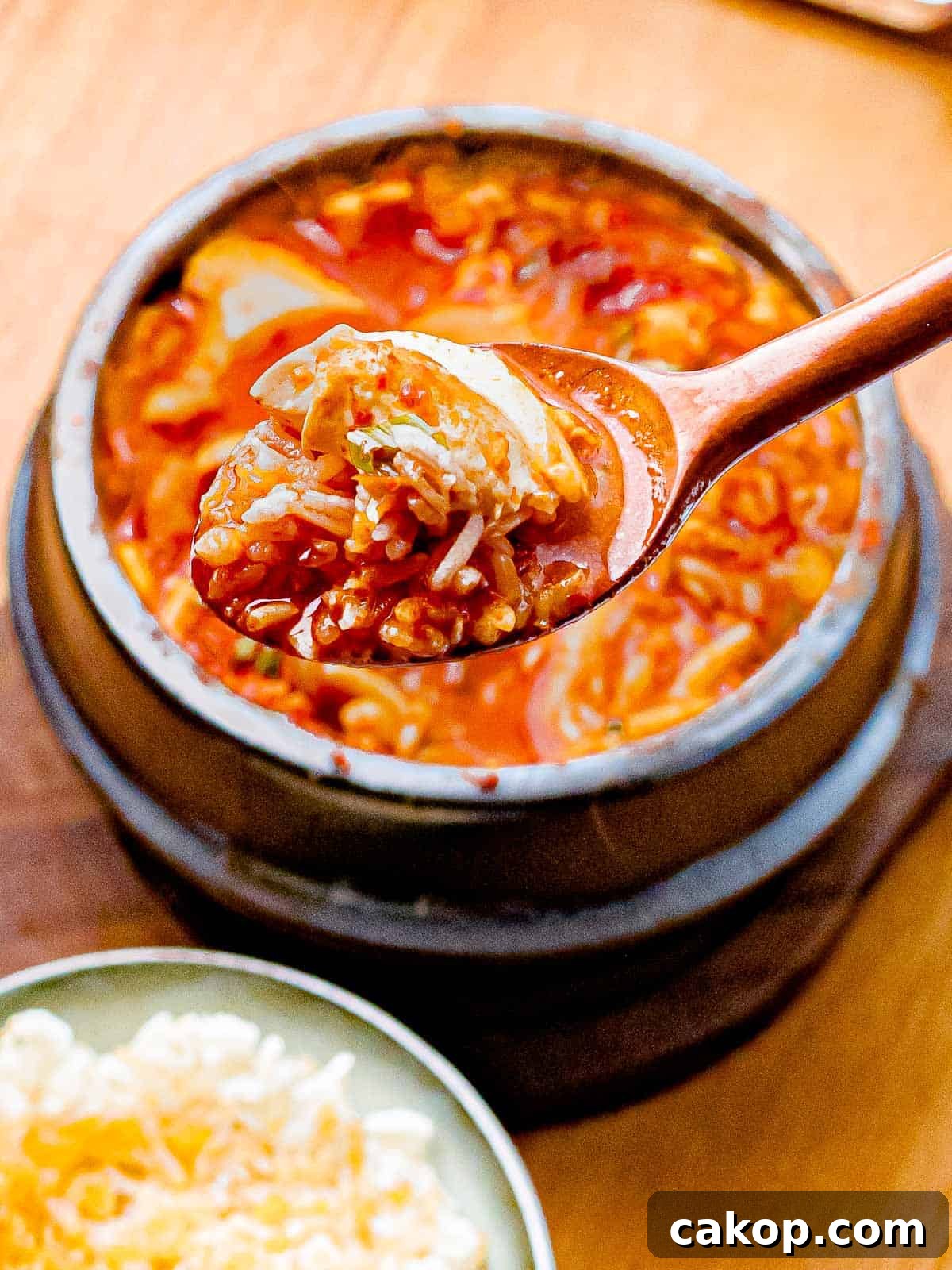 Spicy Korean Soondubu Jjigae (Silken Tofu Stew Recipe) 7 Spoonful of soondubu jiggae with rice.